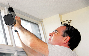 Man drilling a hole in a ceiling